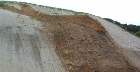 Straw mat hillside sliding away after a few light rainfalls. Should have been terraced with cross drains!